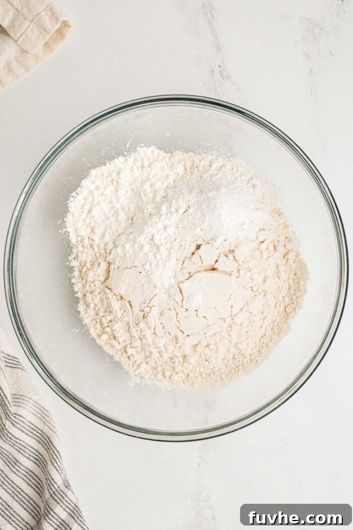 Decadent Vegan Tiramisu 5 Dry baking ingredients like flour, baking powder, baking soda, salt and cornstarch mixed together in a glass mixing bowl.