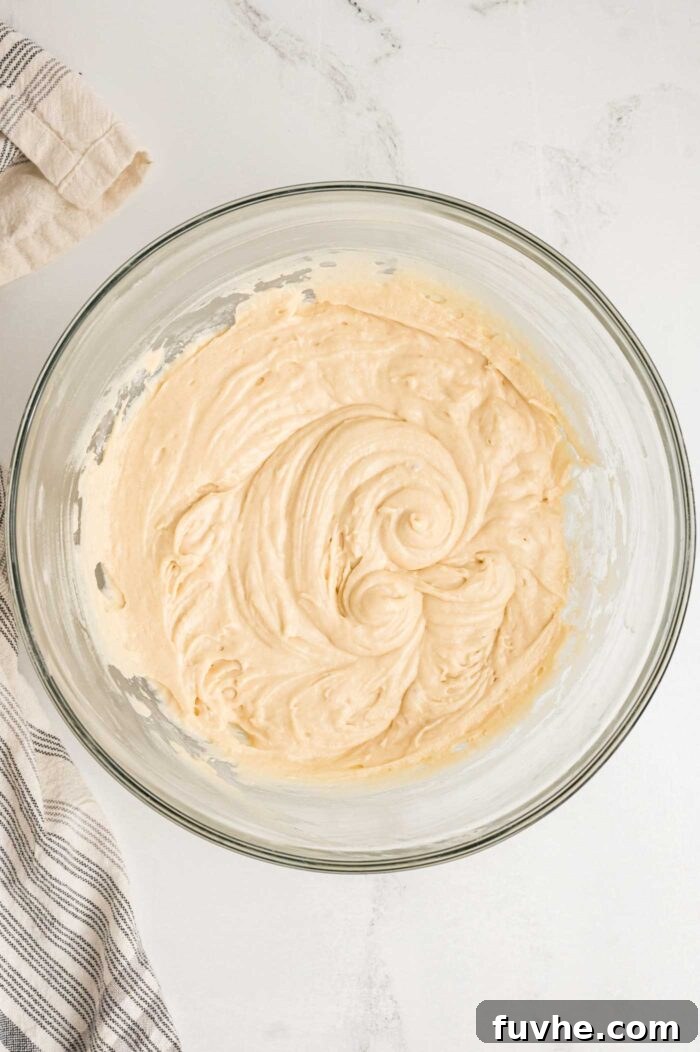 Decadent Vegan Tiramisu 9 Creamy cake batter beaten together in a glass mixing bowl.
