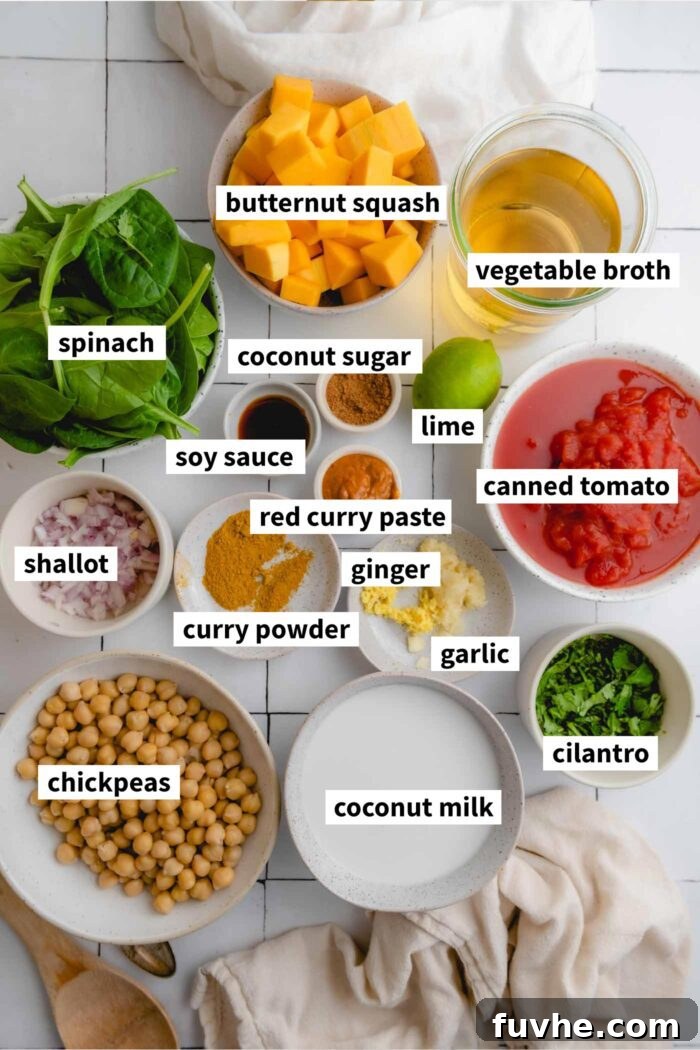 Ingredient collage showcasing all the fresh and pantry staples needed to make butternut squash curry with chickpeas, coconut milk, spinach, red curry paste, ginger, and garlic, neatly arranged on a kitchen counter.