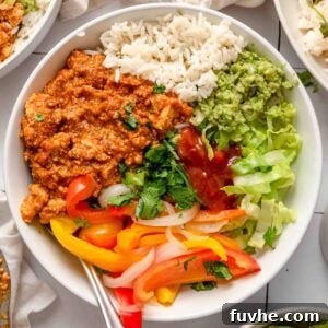 Tofu sofritas burrito bowl with rice, guacamole, cilantro, lettuce and cooked peppers and onions.