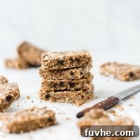 A close-up stack of toasted coconut paleo hemp seed bars, showing texture and ingredients.