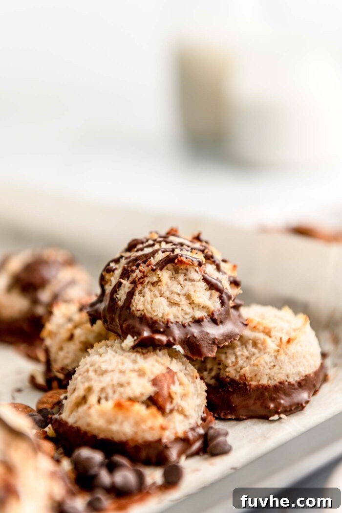 Plant-Powered Almond Coconut Dreams 10 Stack of a few almond macaroons on a baking tray lined with parchment paper.