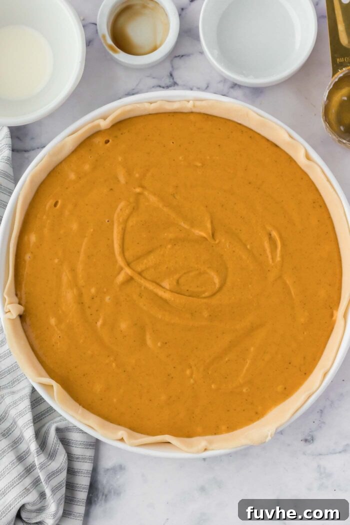 Unbaked sweet potato pie in a pie dish ready to go in the oven.