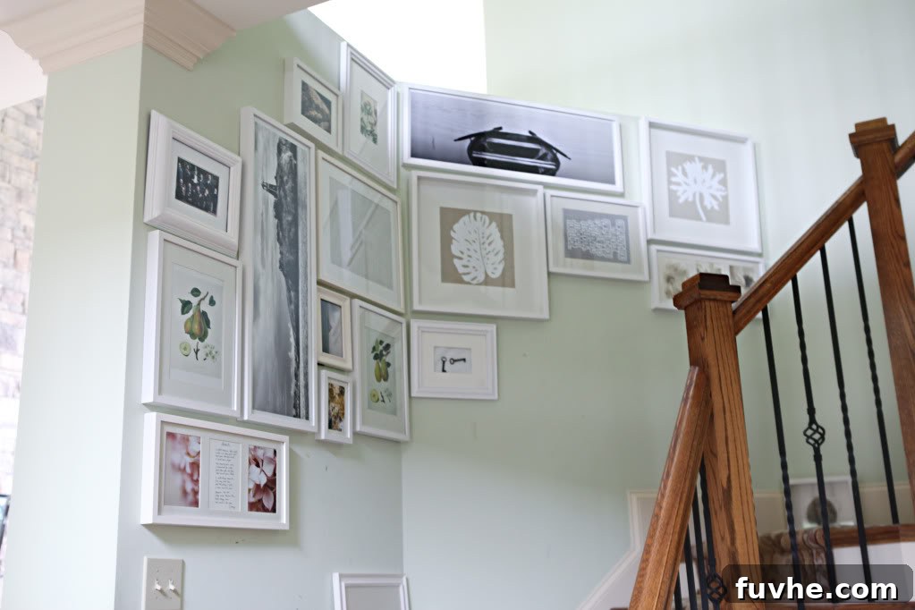 Stairway gallery wall in progress, showing a creative arrangement of frames half complete