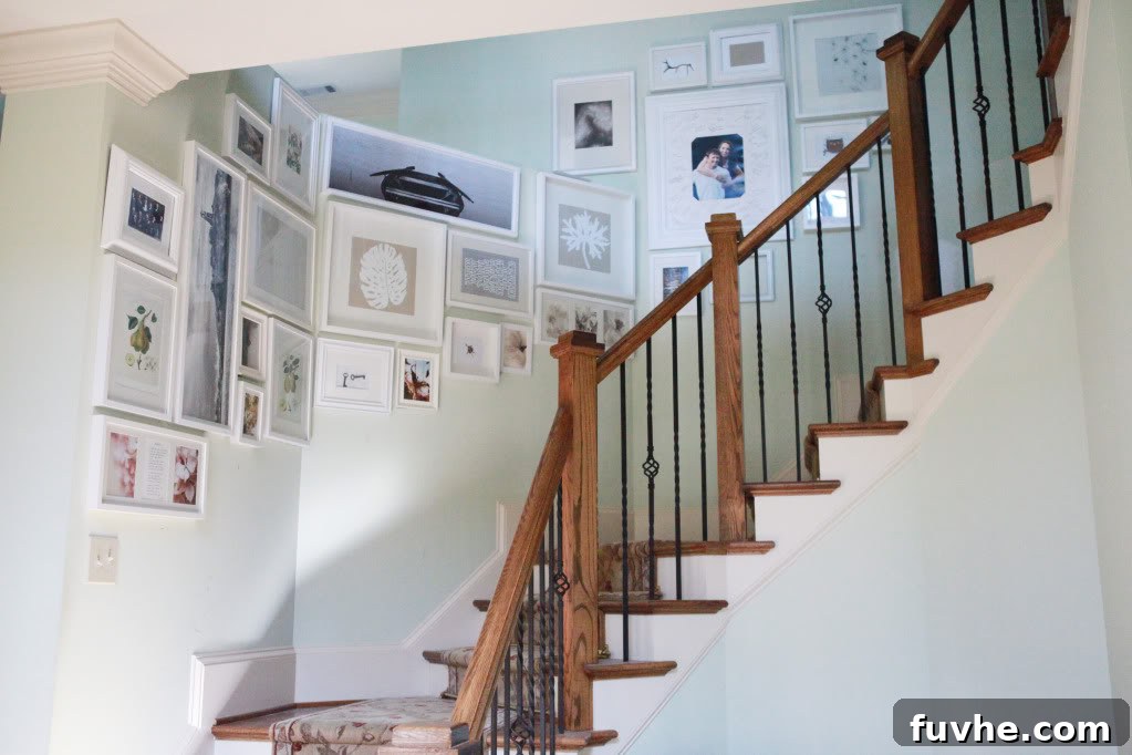 Cohesive stairway gallery wall extending from a half wall to a full wall, showcasing design solution