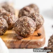 Close up of a chocolate chip energy ball on a cutting board. More balls in background.