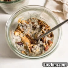 Overhead view of a jar of chia seed pudding with almonds, dates and peanut butter.