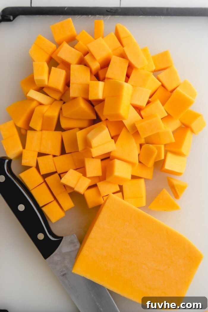 Rustic Wild Rice Salad 4 Cubed butternut squash in a pile on a cutting board with a knife beside it, ready for roasting.