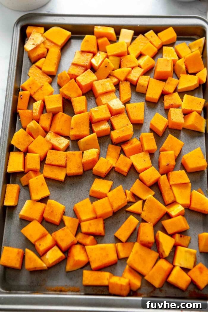 Rustic Wild Rice Salad 5 Cubes of butternut squash tossed in spices on a baking sheet, ready for the oven.