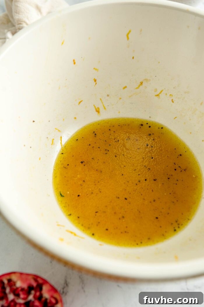 Rustic Wild Rice Salad 6 An orange vinaigrette mixed up in a large bowl, showing its vibrant color and smooth texture.