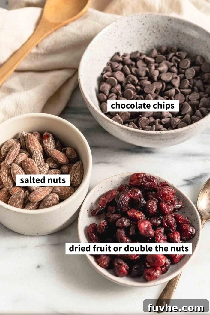Irresistible Nutty Clusters 3 Bowls neatly arranged with the key ingredients: rich chocolate chips, crunchy salted almonds, and vibrant dried cranberries, each component clearly labeled for ease of identification.
