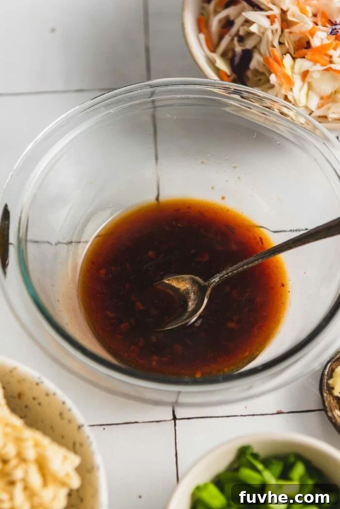 Stir fry sauce in a small glass bowl with spoon in it.