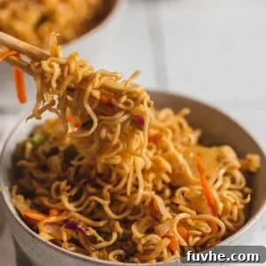 Chopsticks being used in a small bowl of vegetarian pan fried ramen noodles with cabbage.