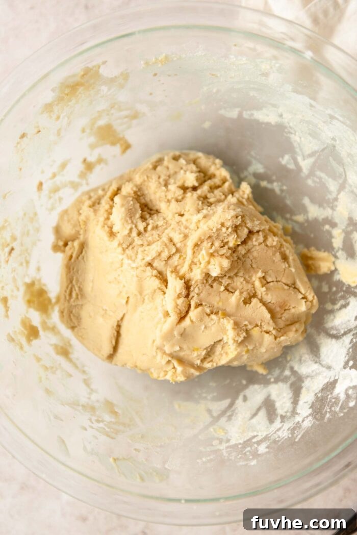 Zesty Lemon Shortbread Bites 5 A ball of shortbread cookie dough in a glass mixing bowl.