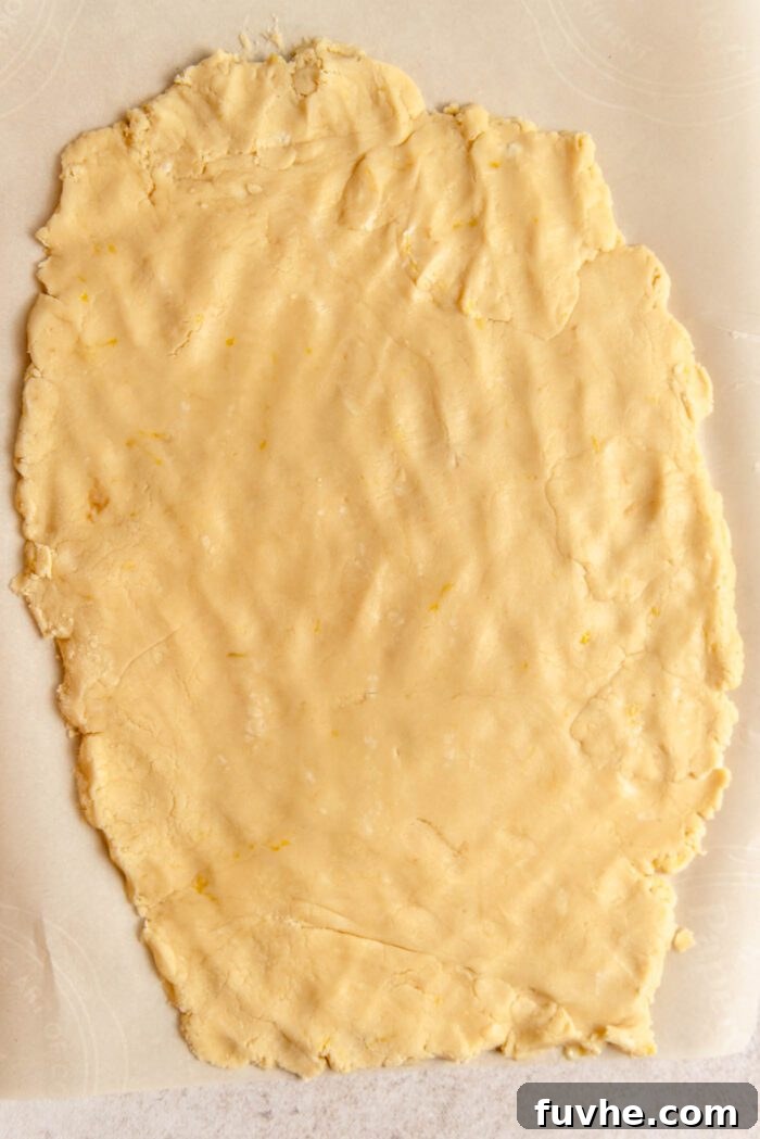 Zesty Lemon Shortbread Bites 6 Shortbread cookie dough rolled 1/4-inch thick on a piece of parchment paper.