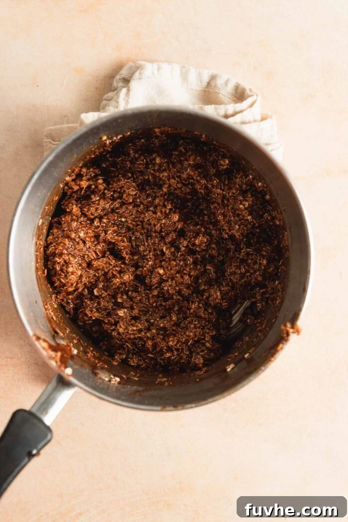 Effortless Vegan Cookie Delights 5 Thick chocolate oatmeal cookie dough, rich and uniform, contained within a small saucepan, ready for shaping.