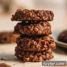 A stack of 4 vegan classic no-bake chocolate cookies sitting on a piece of parchment paper, perfect for a quick and satisfying dessert.