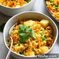 Vegan Pineapple Cashew Cauliflower Rice in a skillet with a wooden spoon.
