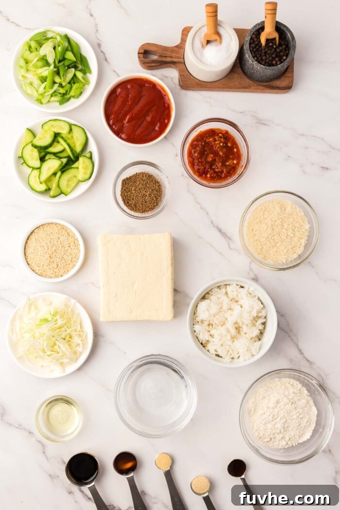 A vibrant display of various ingredients for a complete tofu katsu meal, featuring cooked rice, shredded cabbage, sliced cucumber, and the homemade Tonkatsu sauce in individual dishes.