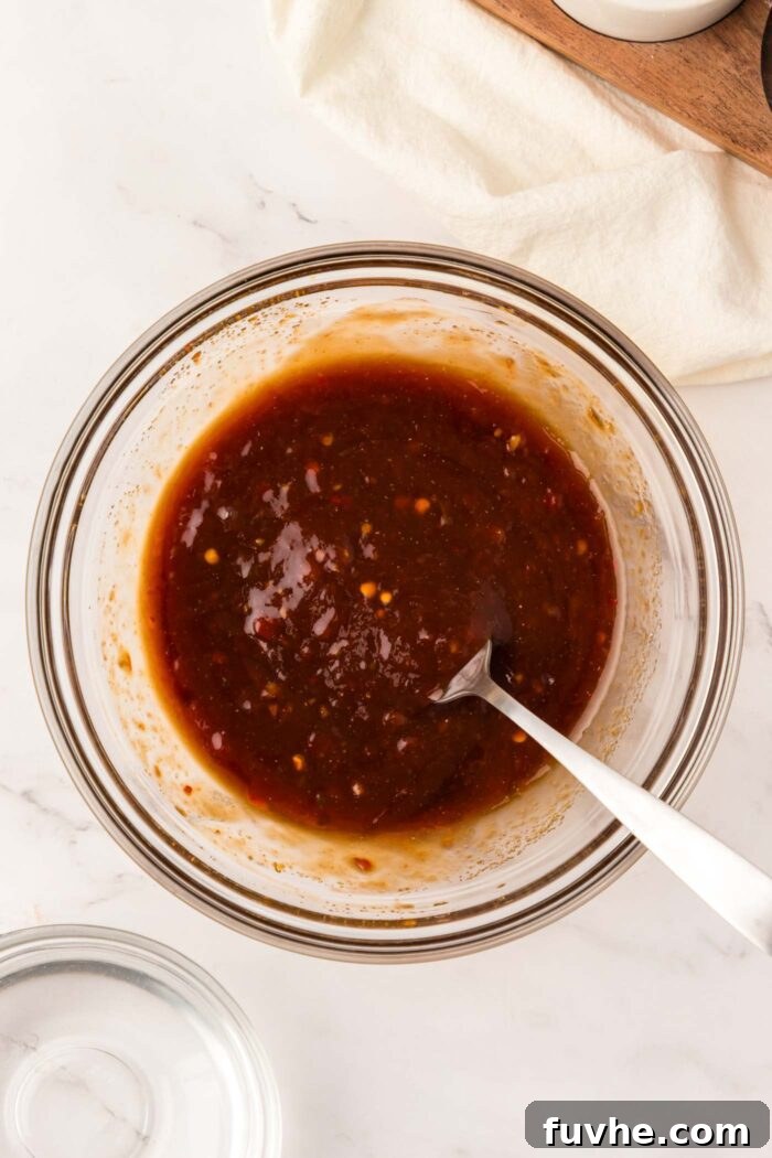 A rich, homemade Tonkatsu-inspired sauce neatly mixed in a glass bowl, with a spoon resting inside, ready for serving.