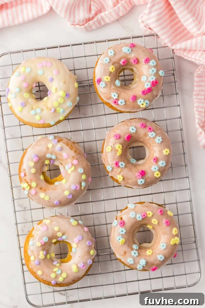 6 glazed donuts with sprinkles on a cooling rack.
