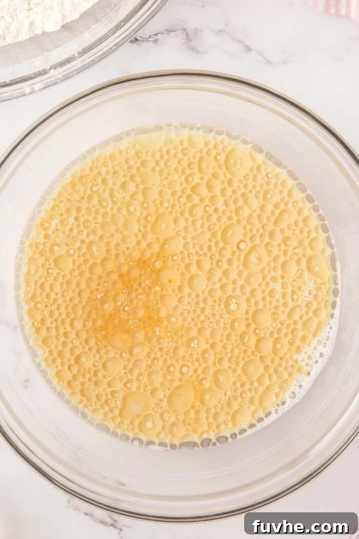 A bubbly liquid mixture in a glass mixing bowl.