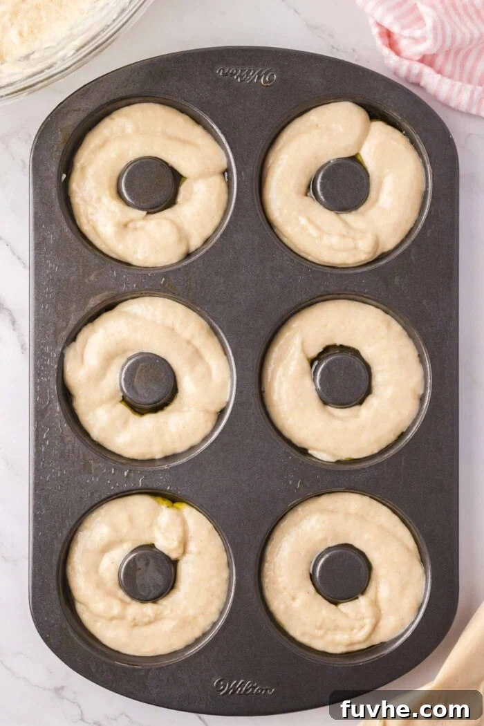 Raw donut batter in a 6 piece donut pan ready to bake.
