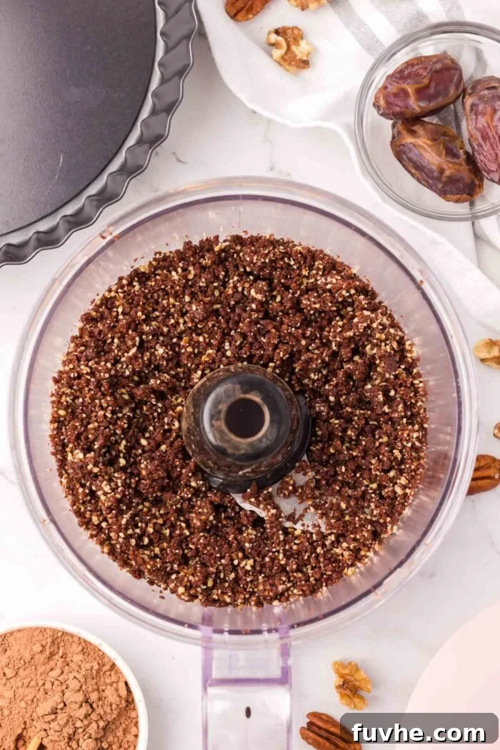 A crumbly chocolate mixture made from nuts and dates in a food processor.