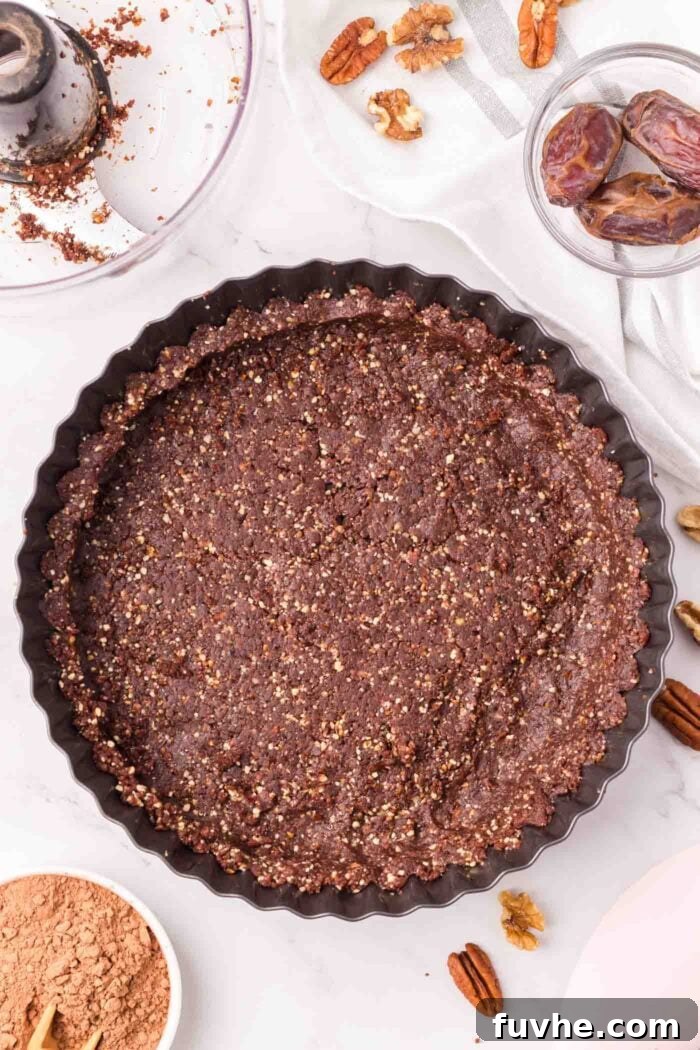 A chocolate crust pressed into a tart pan.
