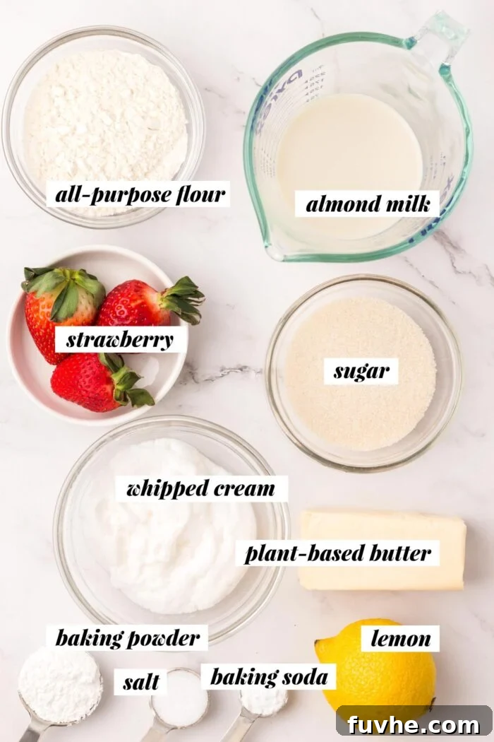 Heavenly Vegan Strawberry Shortcake 3 A collection of fresh ingredients laid out for a vegan strawberry shortcake recipe, including strawberries, plant-based milk, flour, sugar, and vegan butter, each clearly labeled.