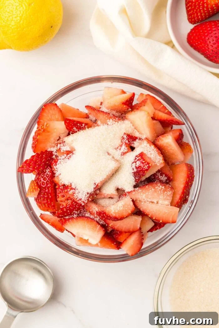 Heavenly Vegan Strawberry Shortcake 4 Freshly sliced strawberries, glistening with granulated sugar, resting in a bowl, beginning the maceration process.