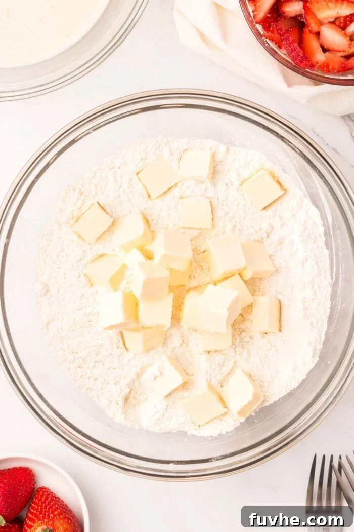 Heavenly Vegan Strawberry Shortcake 7 Cold, cubed vegan butter freshly added to a bowl of flour, ready for blending.