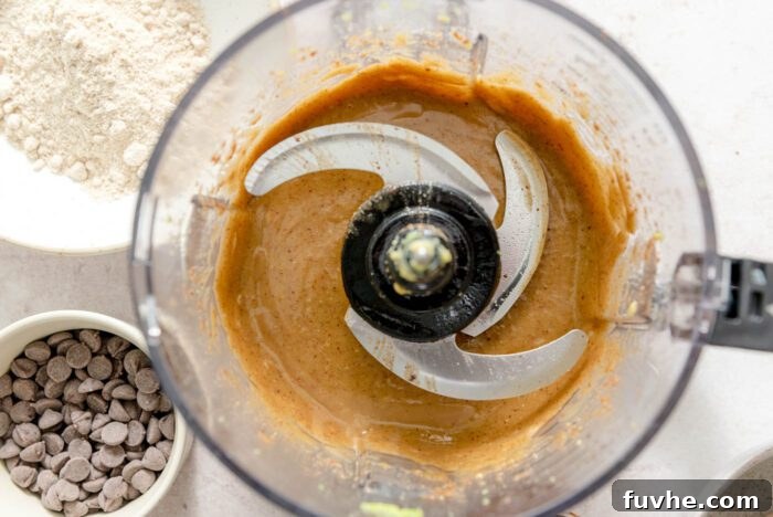 Decadent Vegan Avocado Brownies 4 A creamy caramel-like mixture in a food processor container.