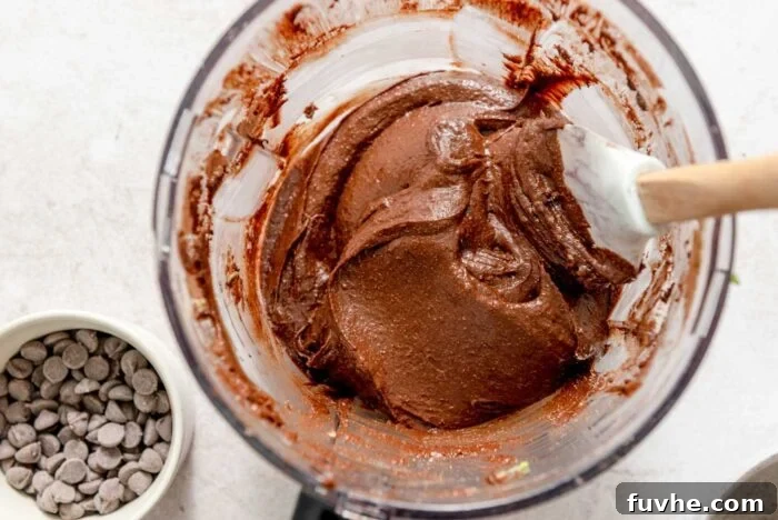 Decadent Vegan Avocado Brownies 5 Chocolate brownie batter in a food processor with a spatula.