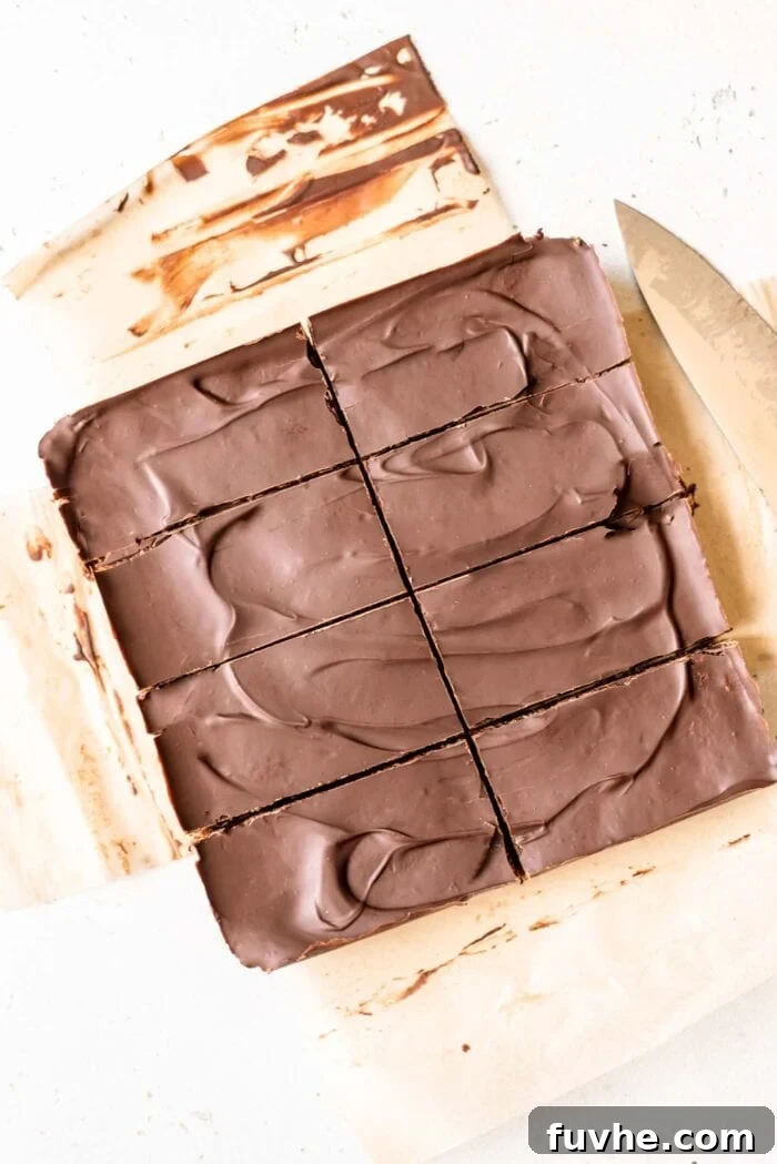 Perfectly sliced chocolate energy bars arranged neatly on parchment paper, highlighting their delicious layers.