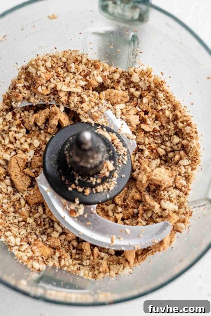 Blended dried apple and nuts in a food processor, showing a more integrated and slightly finer mixture.