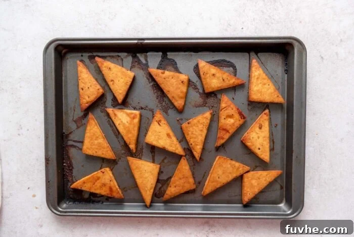 Roasted crispy tofu triangles on a baking sheet.
