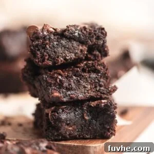A stack of 3 zucchini brownies with chocolate chips in them.