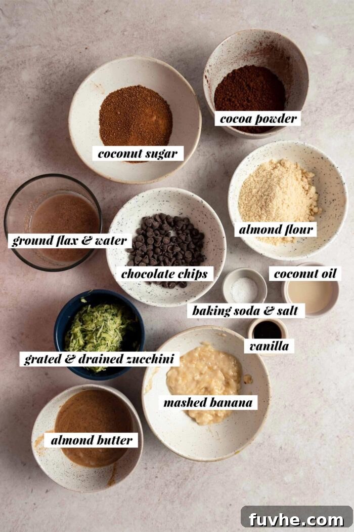 All the ingredients needed for a zucchini brownie recipe gathered in various bowls. Each ingredient is labelled with text overlay.