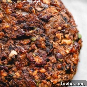 Veggie mushroom burger with black beans, onions and walnuts on a baking sheet lined with parchment paper.
