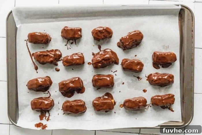 18 small homemade chocolate coated candy bars on a baking sheet lined with parchment paper.