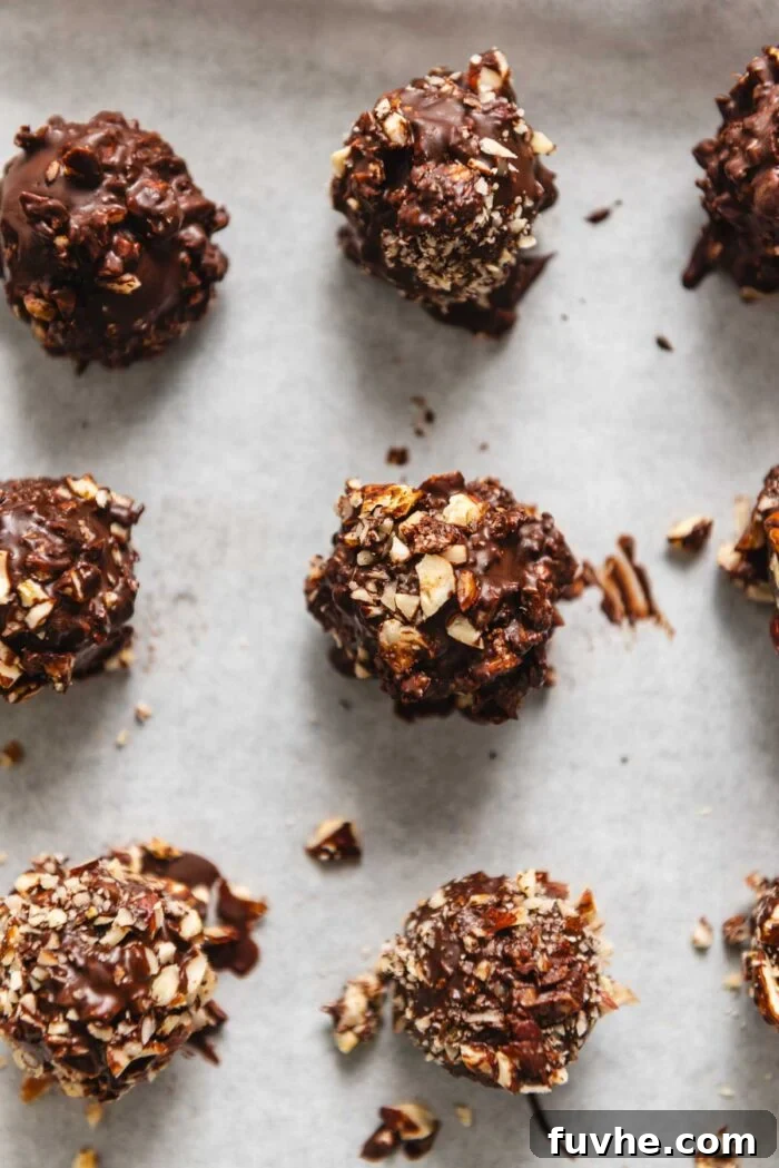 A baking tray of chocolate and hazelnut coated chocolate truffles.