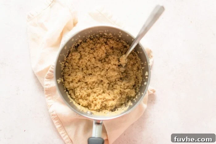 A pot of cooked quinoa with a fork in it.