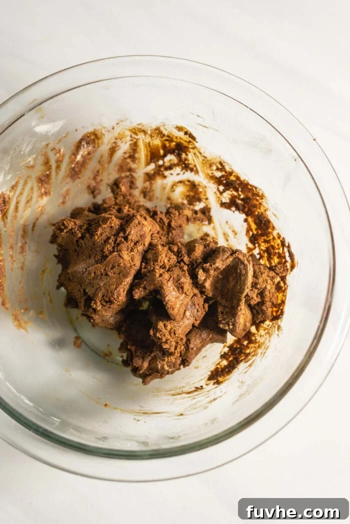 Raw gingerbread cookie dough in a glass mixing bowl.