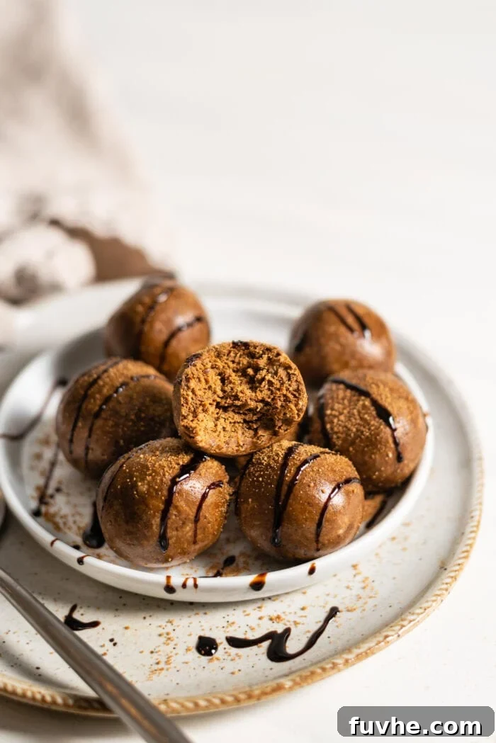 Raw gingerbread ball with a bite take out of it to show the inside texture, which looks like cookie dough.