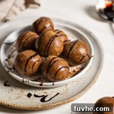 Gingerbread energy balls drizzled with molasses on a small plate.