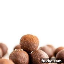 A stack of perfectly formed chocolate energy balls on a plate, ready to be enjoyed.