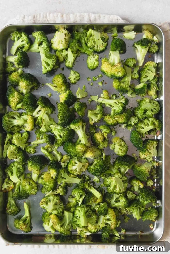 Easy Sheet Pan Sweet Potato Meal 6 Roasted broccoli florets on a baking sheet.