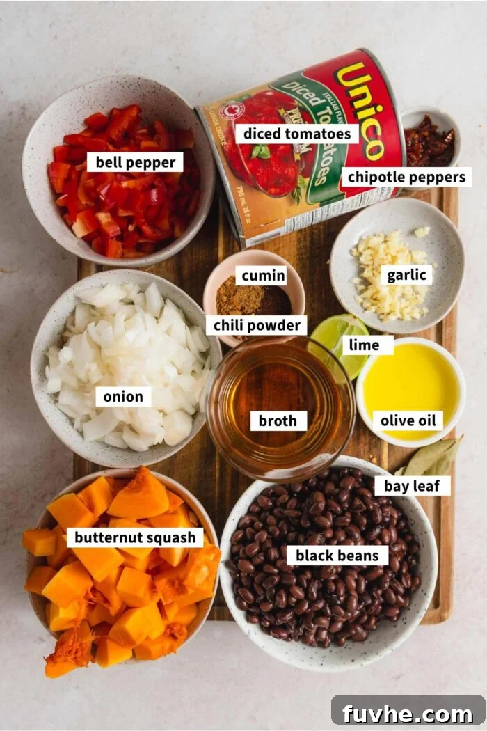 Hearty Butternut Squash Black Bean Chili 3 All the fresh ingredients laid out for preparing a flavorful vegan butternut squash chili recipe, including spices, vegetables, and canned goods.