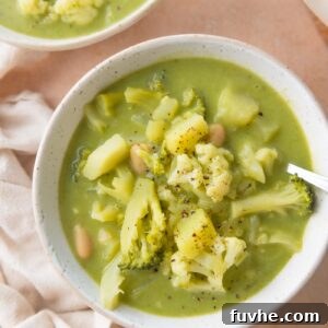 Bowl of soup with broccoli, cauliflower, white beans and potato.